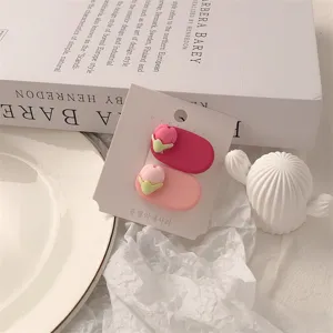 Close-up detail of cute pink flower bud hair clips on a card, aesthetic flat lay accessory.