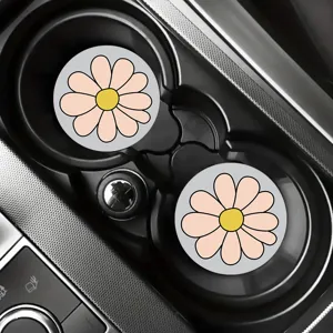 Detailed shot of cute pink daisy flower car coasters placed in car cup holders, soft rubber.