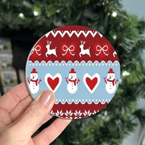 Christmas round coaster with cute knit pixel snowman reindeer pattern for holiday table decor.