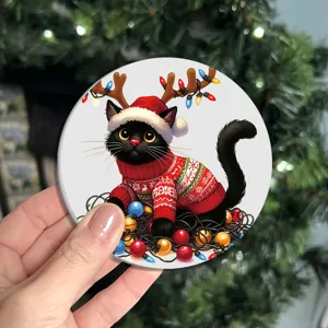 Close-up detail of the cute Christmas black cat round coaster with holiday festive design.