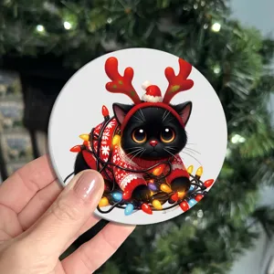 Close-up detail shot of a cute Christmas black cat coaster with reindeer antlers and fairy lights.