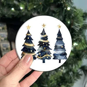 Gros plan détaillé d'un sous-verre de Noël rond avec un motif d'arbre aquarelle bleu et or.
