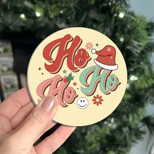 Detail shot of a retro Christmas Ho Ho Ho coaster featuring cute festive hat and smiley designs.