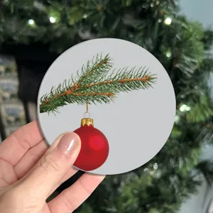 Sous-verre rond de Noël avec motif de branche de pin et boule rouge pour table.