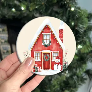 Primo piano del sottobicchiere rotondo di Natale con una bella casa rossa e un pupazzo.