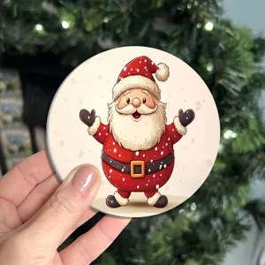 Round Christmas coaster with cute Santa Claus design, ceramic surface and absorbent cork base.