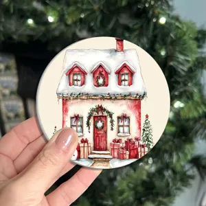 Primo piano dettagliato di un sottobicchiere rotondo natalizio con casetta innevata.