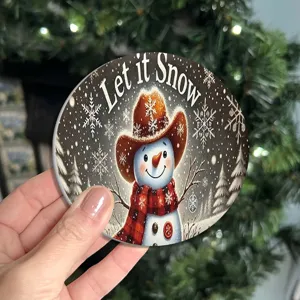 Close-up detail of round Christmas snowman coaster with festive design for table decor.