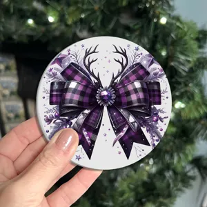 Close-up detail of a round Christmas coaster with a purple plaid bow and deer antler design.