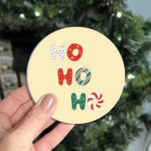 Close-up of a festive Christmas cup coaster featuring cute HO HO HO lettering and holiday patterns.