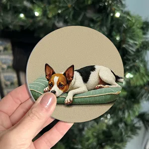 Close-up detail of a round decorative coaster featuring a cute puppy resting on a green cushion.