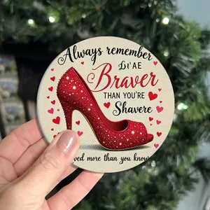 Primer plano de un posavasos redondo decorativo con zapato de tacón rojo brillante y corazones.