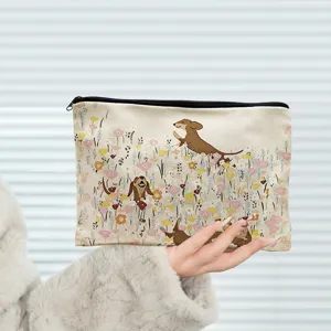 Vue détaillée de la trousse de maquillage en toile avec motif de teckel et fleurs.