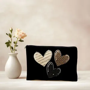 Gros plan sur la trousse de maquillage en toile noire avec des motifs de cœur léopard et musique.