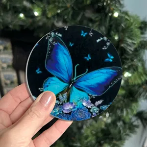 Sottobicchiere assorbente in silicone rotondo con stampa floreale a farfalla blu.