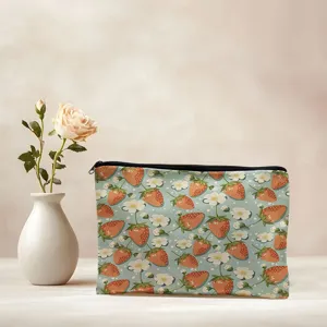 Close-up detail of a charming strawberry patterned cosmetic zipper pouch on light table.
