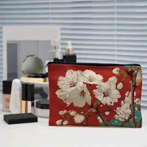 Floral print makeup pouch detail view featuring vibrant cherry blossoms on red fabric.