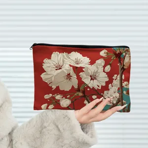 Detail shot of portable red cherry blossom cosmetic makeup pouch with smooth zipper closure design.