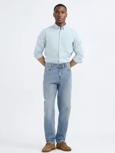 Classic light wash loose straight fit denim jeans styled with a light blue long sleeve shirt.