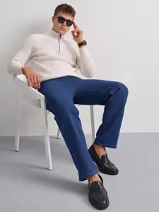 Detailed view of classic straight-fit men's jeans paired with stylish knit sweater.