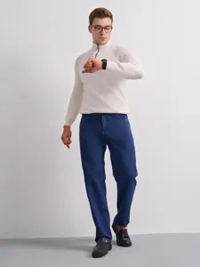 Men's casual straight fit denim jeans paired with white ribbed half zip sweater outfit.