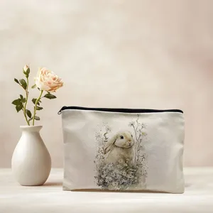Linen makeup bag detail showing cute watercolor rabbit print and smooth black zipper closure.