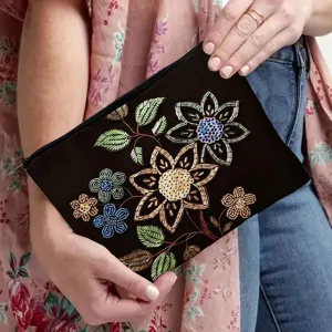 Detailopname van zwart canvas cosmetica tasje met ingewikkelde kleurrijke kraal bloemenborduurwerk.
