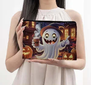 Detailed view of the Halloween ghost and pumpkin print cosmetic pouch held by a model.