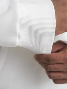 Close-up of white men's hoodie ribbed cuff detail, showing premium cotton fabric texture.