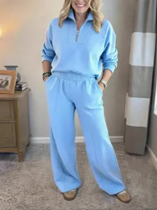 Detailed view of the light blue half-zip sweatshirt and wide-leg pants loungewear set worn.