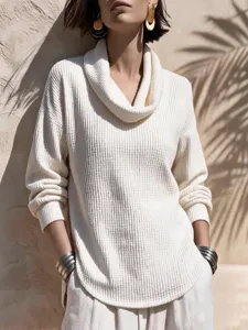 Detailansicht des weißen gerippten Strickoberteils mit elegantem Wasserfallkragen.