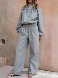 Detail view of light blue casual tracksuit jacket and wide leg pants set street style.