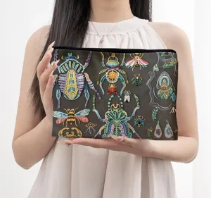 Gedetailleerde opname van het canvas cosmetische tasje met kleurrijk insectenprint.