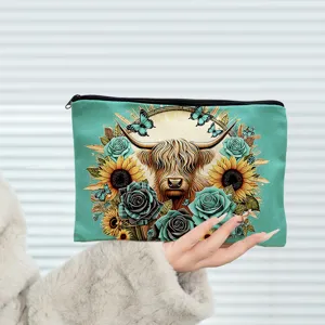 Close-up detail of the canvas makeup bag featuring vibrant Highland cow and floral print.