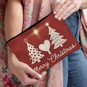 Christmas cosmetic bag detail, red canvas makeup pouch with festive tree prints and zipper.