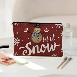 Close-up detail of a festive red makeup pouch featuring a cute snowman print and let it snow text.