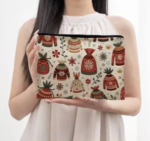 Gros plan détaillé d'une pochette cosmétique portable au motif de pull et flocon d'hiver.