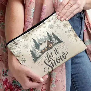 Close-up detail shot of a canvas makeup pouch featuring a cozy winter cabin and snow print.