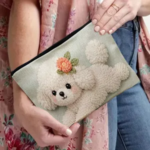 Dettaglio ravvicinato della borsa cosmetica in tela con motivo di barboncino bianco.