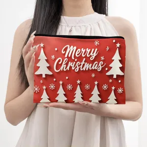 Red Christmas tree print linen cosmetic pouch zipper toiletry bag held in hand display.