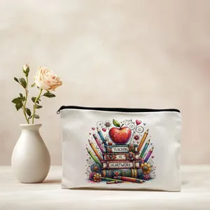 Detail shot of the canvas zipper pouch featuring a teacher heartwork graphic and apple print.