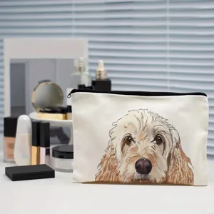 Close-up shot of canvas makeup bag featuring cute fluffy dog illustration and sturdy black zipper.