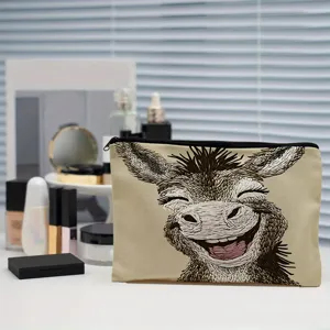 Détail de trousse de maquillage en toile avec imprimé âne mignon et fermeture éclair pratique.