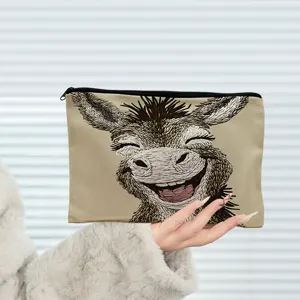 Gros plan détaillé de la trousse de maquillage en toile avec motif d'âne souriant.