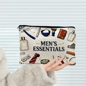 Detail de trousse de toilette en toile affichant impression essentials et fermeture eclair.