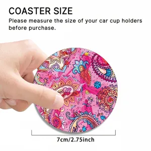 Close-up detail of a colorful paisley pattern car coaster, showing size and hand holding.