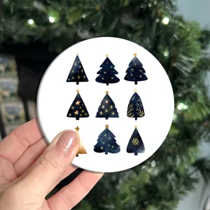 Close up detail of round silicone Christmas tree coaster with gold star watercolor pattern.