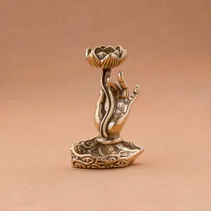 Brass lotus hand backflow incense burner detail, intricate Buddha hand sculpture craft.