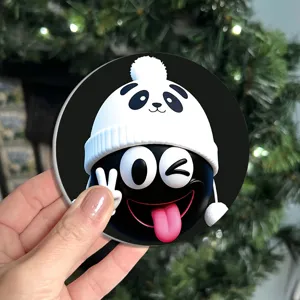 Detaillierte Nahaufnahme eines lustigen runden Cartoon-Emoji-Untersetzers mit weißem Pandahut.
