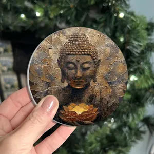Nahaufnahme eines runden Deko-Untersetzers mit goldenem Buddha-Motiv und Lotusblüte.
